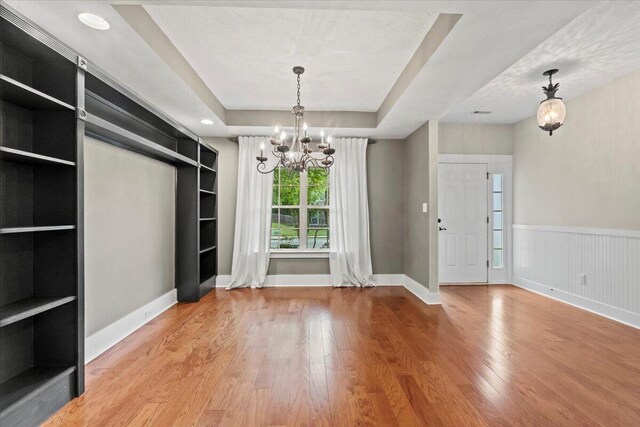 459 Sebastian Dr, Grovetown, GA 30813 - unfurnished dining area featuring wood finished floors, a chandelier, built in features, and a tray ceiling