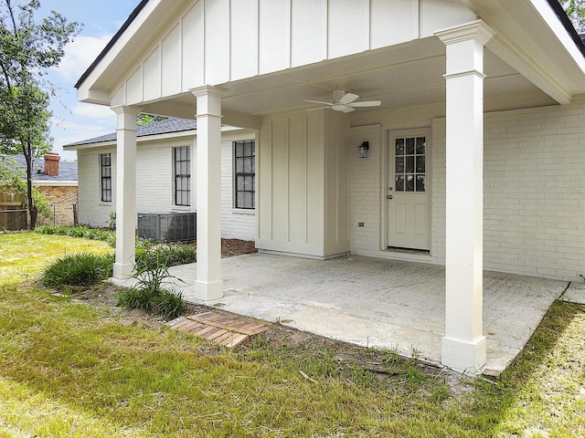 exterior space featuring a patio, ceiling fan, board and batten siding, and brick siding