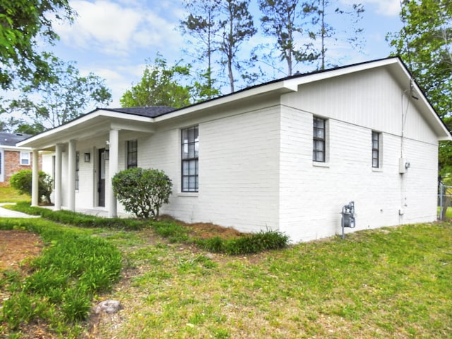 view of property exterior featuring a lawn and brick siding