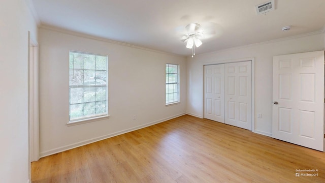 unfurnished bedroom with baseboards, crown molding, and light wood-style flooring