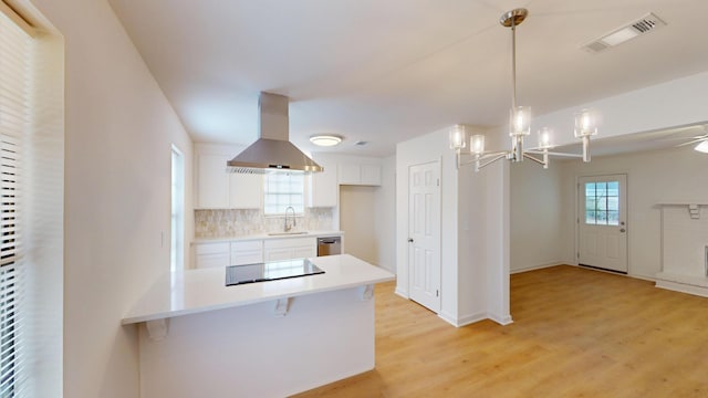 kitchen with exhaust hood, black electric cooktop, visible vents, light countertops, and white cabinets