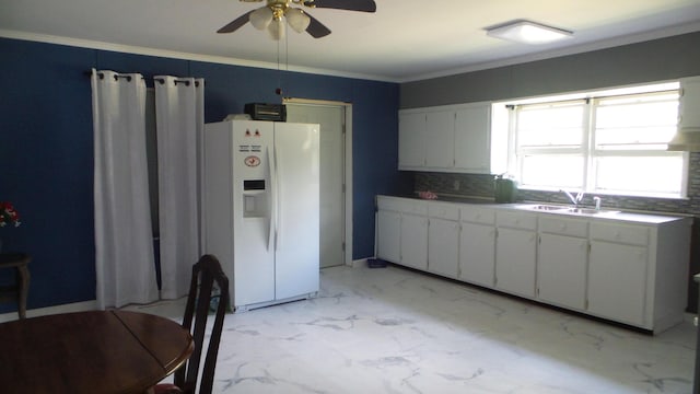 kitchen with ceiling fan, crown molding, sink, white cabinetry, and white fridge with ice dispenser