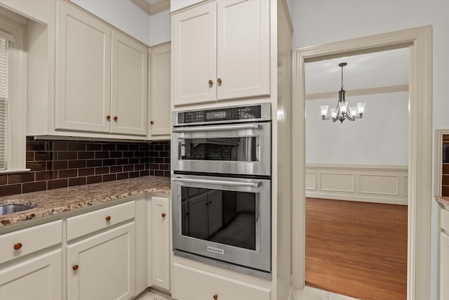 4119 N Knollcrest Cir, Martinez, GA 30907 - kitchen with double oven, decorative backsplash, a chandelier, light stone countertops, and ornamental molding