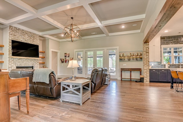 2550 Otts Ln, Harlem, GA 30814 - living area featuring light wood-type flooring, a fireplace, coffered ceiling, beam ceiling, and a chandelier