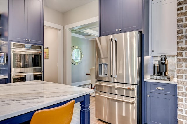 2550 Otts Ln, Harlem, GA 30814 - kitchen featuring appliances with stainless steel finishes, light stone countertops, decorative backsplash, and light wood finished floors