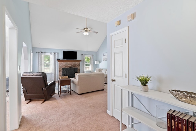 222 Canterbury Dr, Wrens, GA 30833 - carpeted living area with ceiling fan, lofted ceiling, a brick fireplace, and a textured ceiling