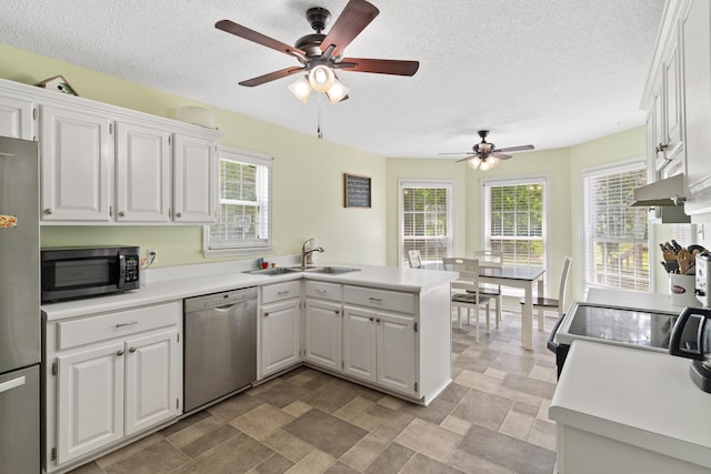 222 Canterbury Dr, Wrens, GA 30833 - kitchen featuring stainless steel appliances, a peninsula, a ceiling fan, white cabinetry, and light countertops