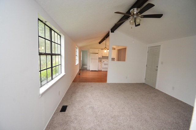 unfurnished living room featuring lofted ceiling with beams, ceiling fan, and light colored carpet