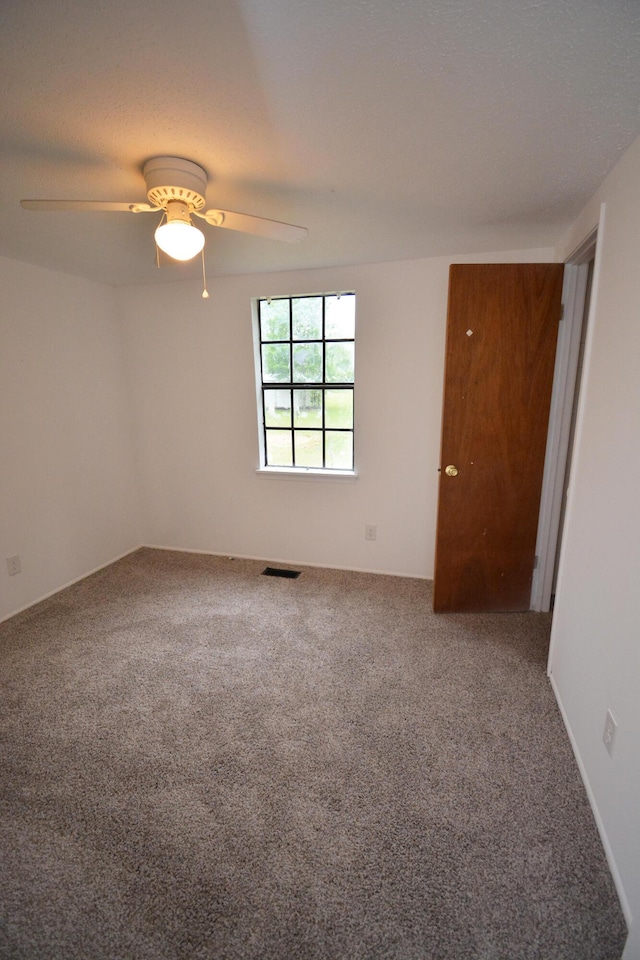 unfurnished room featuring ceiling fan and carpet floors