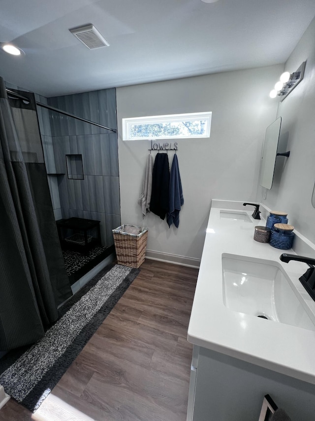 2786 Tudor Rd, Dearing, GA 30808 - bathroom featuring double vanity, tiled shower, and wood finished floors