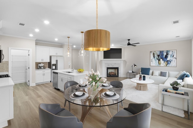 kitchen with white cabinetry, hanging light fixtures, stainless steel appliances, dark hardwood / wood-style flooring, and a kitchen island with sink