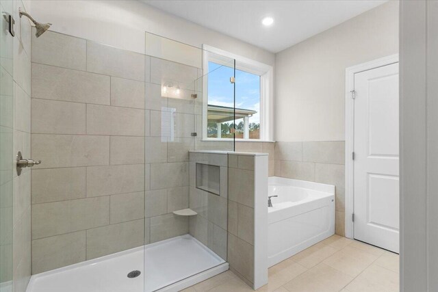 bathroom featuring tile patterned flooring and shower with separate bathtub