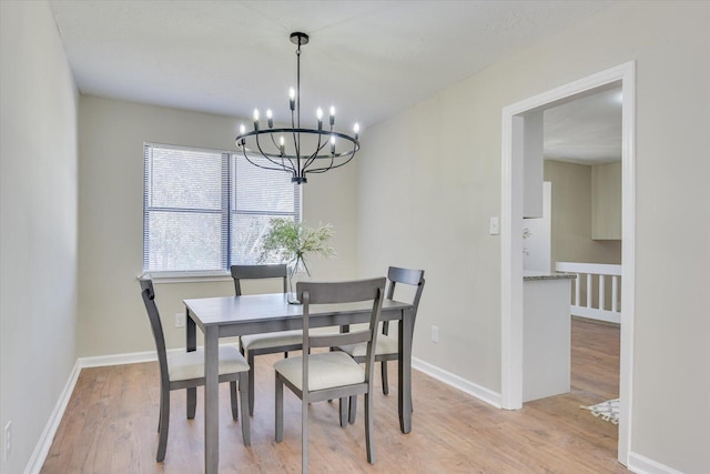 dining space featuring light hardwood / wood-style floors and a notable chandelier