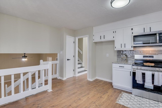 kitchen with decorative backsplash, stainless steel appliances, ceiling fan, light hardwood / wood-style flooring, and white cabinets