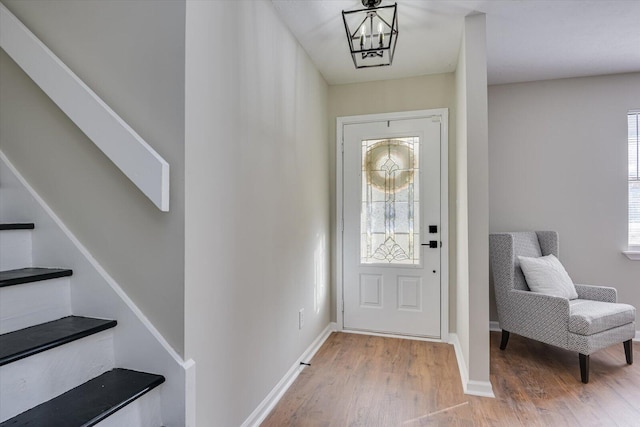 foyer entrance with a chandelier and wood-type flooring