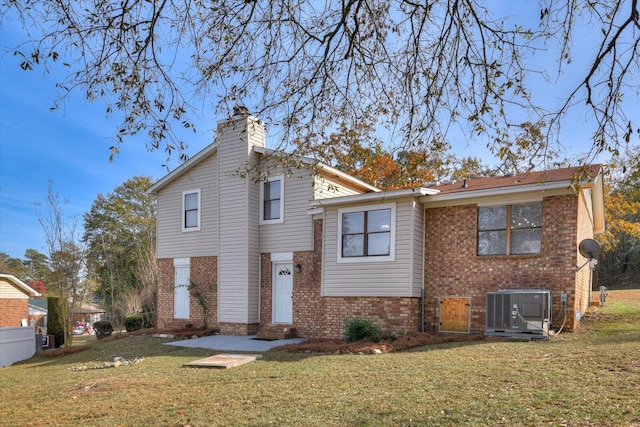 back of house with a yard and central AC