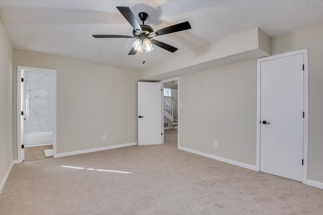 unfurnished bedroom with ensuite bath, ceiling fan, and light colored carpet