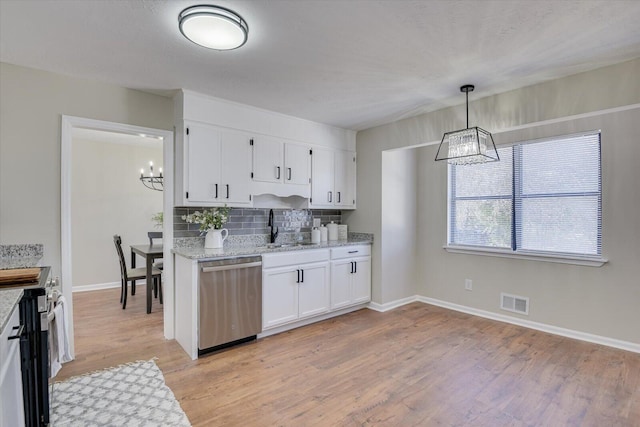 kitchen featuring sink, tasteful backsplash, pendant lighting, white cabinets, and appliances with stainless steel finishes