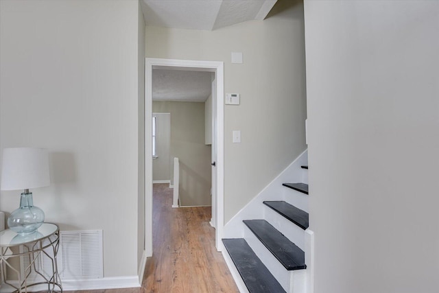 stairs featuring hardwood / wood-style flooring