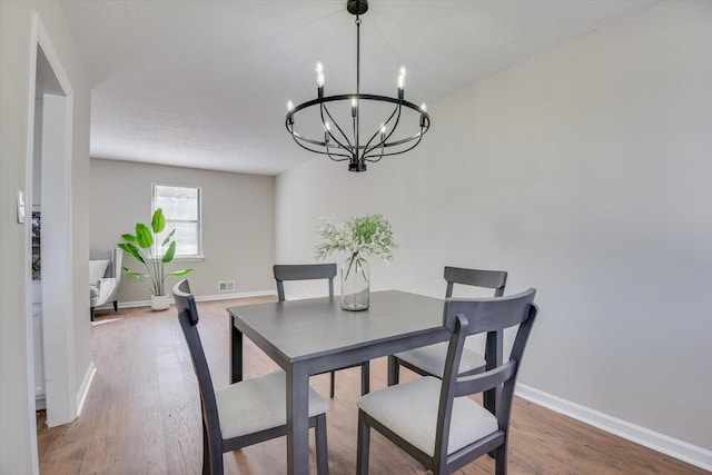 dining space with a chandelier and hardwood / wood-style flooring