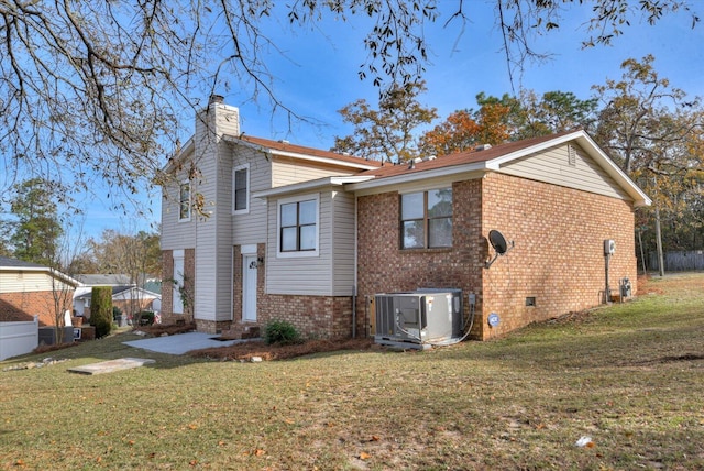 back of property with central AC unit and a lawn