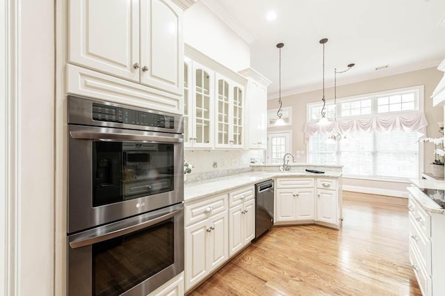 kitchen with ornamental molding, a peninsula, light wood-style floors, white cabinets, and appliances with stainless steel finishes