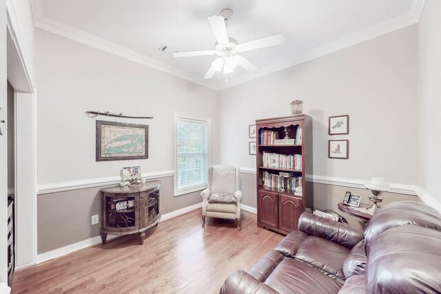 living room featuring crown molding, light hardwood / wood-style flooring, and ceiling fan