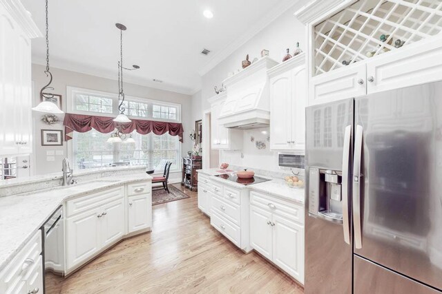 kitchen with light stone countertops, premium range hood, stainless steel appliances, white cabinetry, and hanging light fixtures