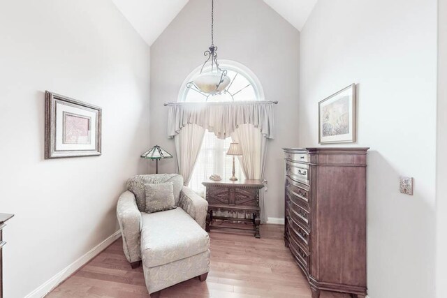 living area with light wood-type flooring and vaulted ceiling