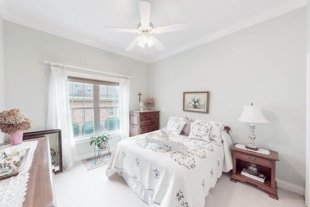 bedroom featuring ceiling fan, ornamental molding, and light carpet