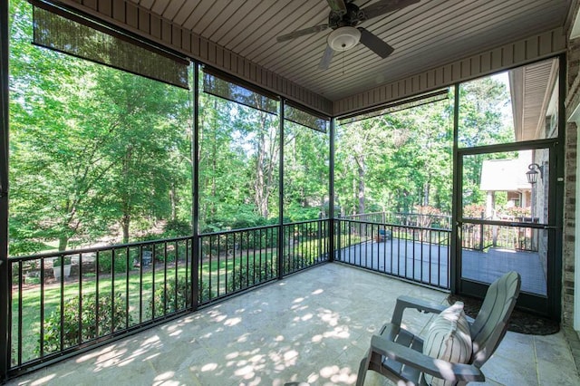 unfurnished sunroom featuring a ceiling fan