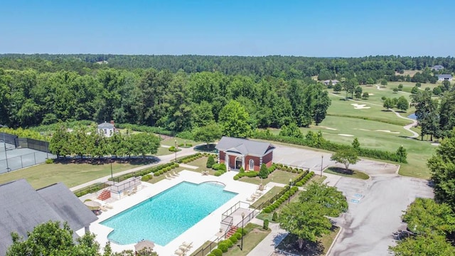 aerial view featuring view of golf course and a wooded view