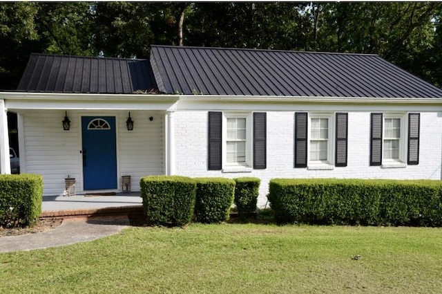 505 Ridgeland Dr, Sandersville, GA 31082 - view of front of home with a front lawn, a metal roof, a standing seam roof, a porch, and brick siding