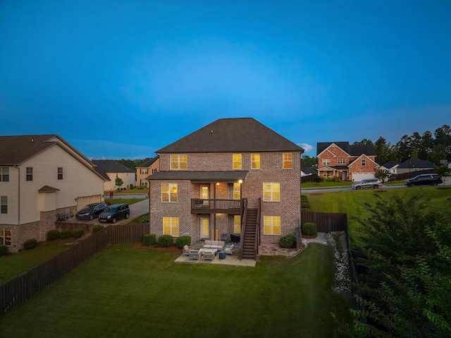 1206 Arcilla Pt, Martinez, GA 30907 - back of property at dusk with outdoor lounge area, a patio, a balcony, brick siding, and stairs