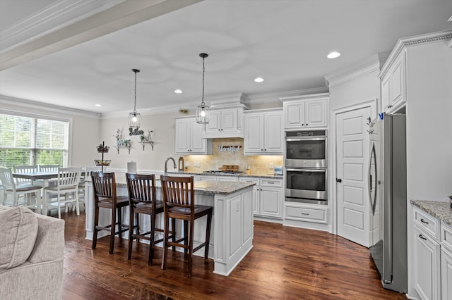 1206 Arcilla Pt, Martinez, GA 30907 - kitchen with stainless steel appliances, white cabinetry, a breakfast bar, dark wood-type flooring, and recessed lighting
