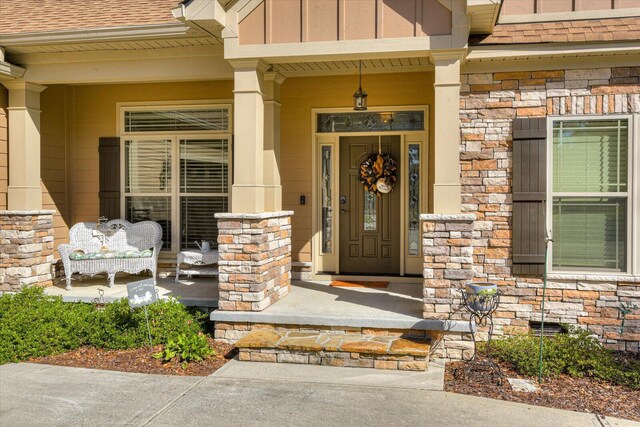 entrance to property featuring covered porch and a wall mounted air conditioner