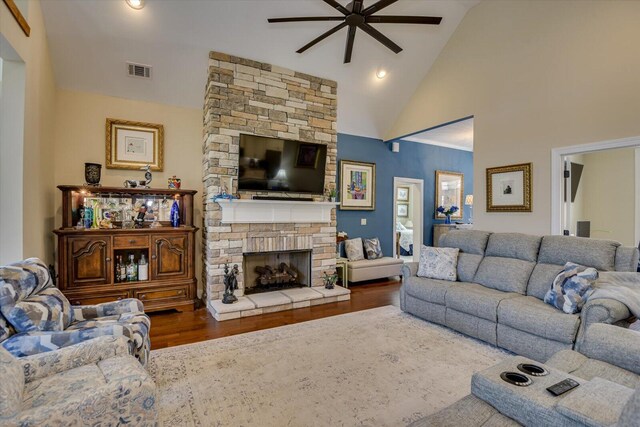 living room with ceiling fan, a fireplace, high vaulted ceiling, and wood-type flooring