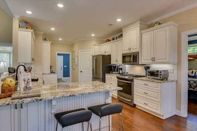 106 Bereau Dr, Mccormick, SC 29835 - kitchen with stainless steel appliances, a peninsula, decorative backsplash, crown molding, and light stone countertops