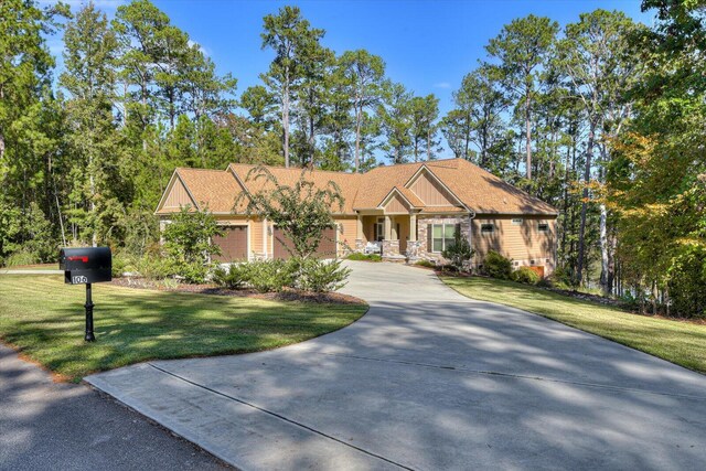 craftsman house with a front yard and a garage