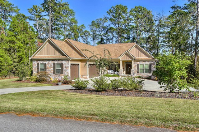 craftsman inspired home with a garage and a front lawn