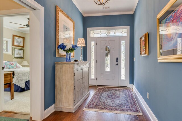 foyer entrance with wood-type flooring, ceiling fan, and ornamental molding