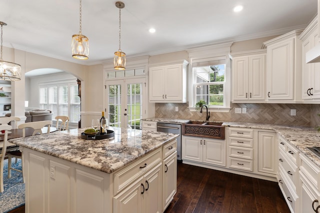 2224 Fothergill Dr, Evans, GA 30809 - kitchen with stainless steel dishwasher, arched walkways, a sink, light stone counters, and dark wood-style floors