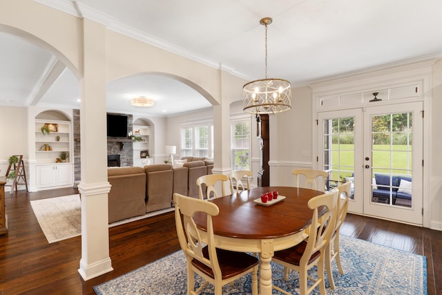 2224 Fothergill Dr, Evans, GA 30809 - dining room featuring dark wood-style flooring, crown molding, a fireplace, arched walkways, and french doors