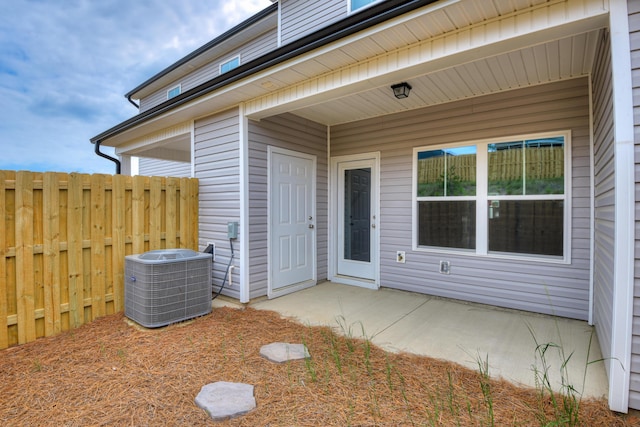 doorway to property featuring a patio area and cooling unit