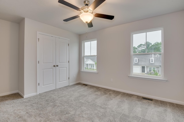 unfurnished bedroom with ceiling fan, a closet, and light colored carpet