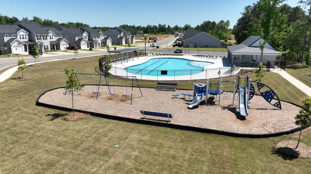 pool featuring playground community, a residential view, and a yard