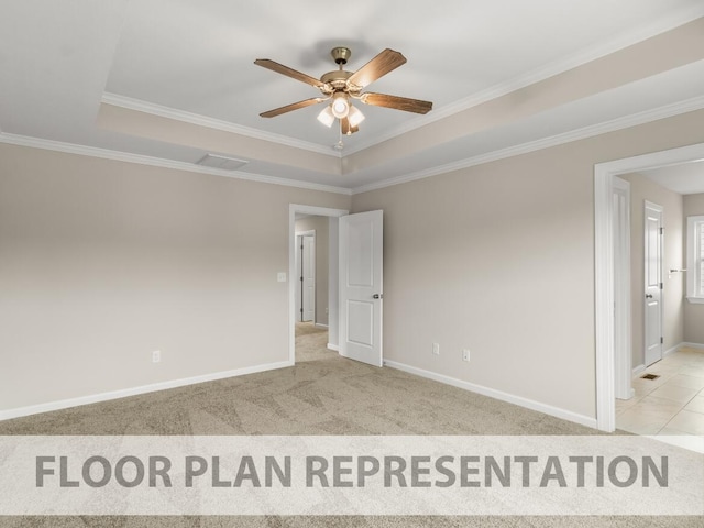 carpeted empty room with tile patterned floors, a tray ceiling, crown molding, baseboards, and ceiling fan