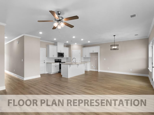 kitchen featuring visible vents, a breakfast bar, white cabinetry, appliances with stainless steel finishes, and decorative backsplash