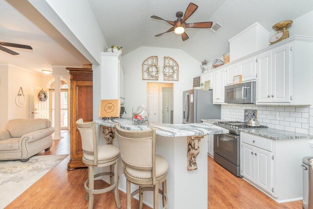 2108 Glenn Fls, Grovetown, GA 30813 - kitchen featuring ceiling fan, stainless steel appliances, a breakfast bar area, light wood finished floors, and backsplash