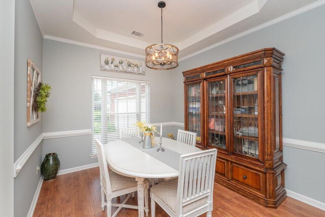 2108 Glenn Fls, Grovetown, GA 30813 - dining area with a chandelier, wood finished floors, a raised ceiling, baseboards, and crown molding